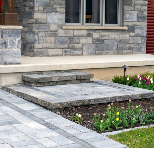 close up of front residential lanscaping, paver driveway, brick patio, concrete steps