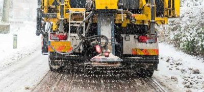 snow removal truck pouring salt on the road so that it will not be slippery
