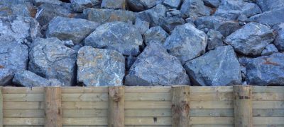 large boulder rocks behind the wooden wall